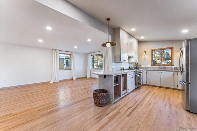 8120 W 54th Pl, Arvada, CO 80002 - kitchen with stainless steel appliances, recessed lighting, light wood-style flooring, a peninsula, and hanging light fixtures