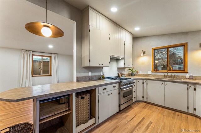 8120 W 54th Pl, Arvada, CO 80002 - kitchen featuring high end stove, a sink, light wood-type flooring, recessed lighting, and wine cooler