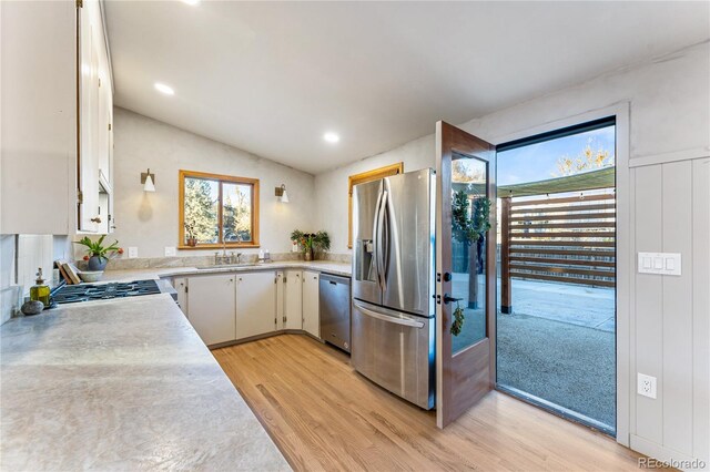 8120 W 54th Pl, Arvada, CO 80002 - kitchen with stainless steel appliances, light countertops, light wood-type flooring, a sink, and lofted ceiling