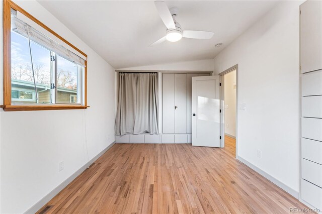 8120 W 54th Pl, Arvada, CO 80002 - unfurnished bedroom with lofted ceiling, light wood-type flooring, baseboards, a ceiling fan, and a closet