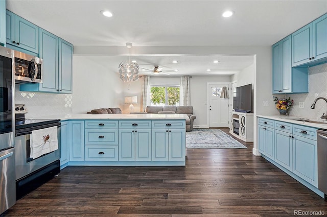 6655 S Elm Cir, Centennial, CO 80121 - kitchen with stainless steel appliances, a sink, a peninsula, blue cabinets, and open floor plan