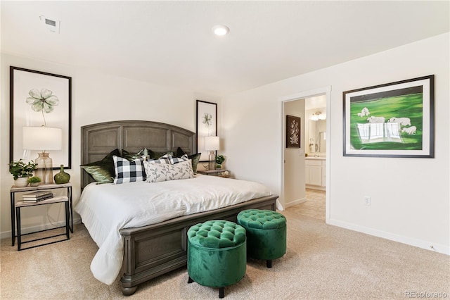 bedroom with light colored carpet and ensuite bathroom