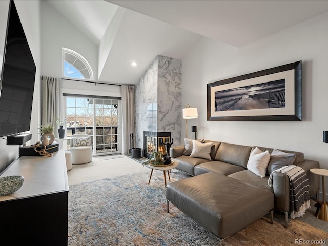 living area featuring vaulted ceiling and a premium fireplace