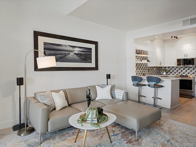 living room featuring baseboards and visible vents