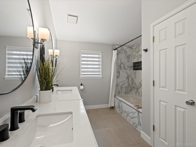 full bathroom featuring baseboards, shower / bath combo with shower curtain, a sink, and double vanity