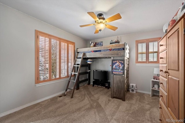 carpeted bedroom with ceiling fan and multiple windows