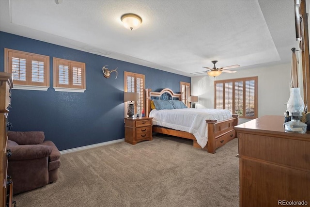 bedroom featuring ceiling fan, light colored carpet, and a textured ceiling