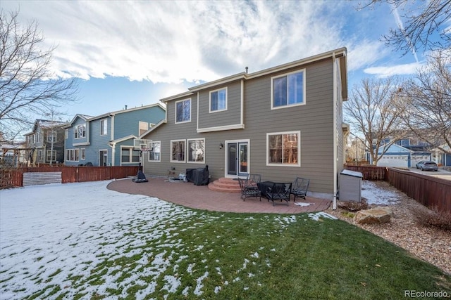 snow covered house featuring a yard and a patio