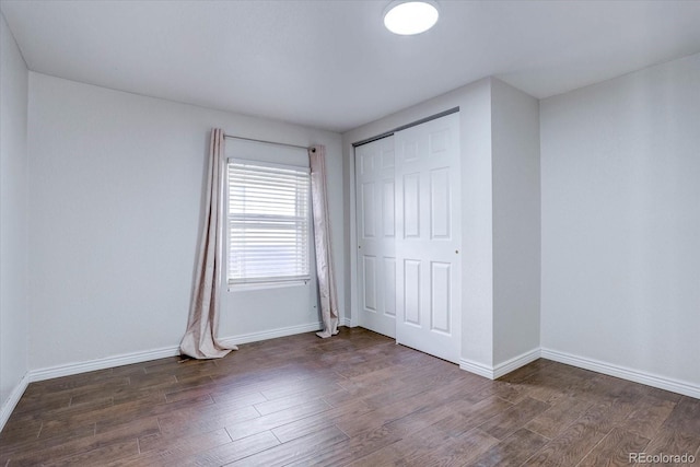 unfurnished bedroom with a closet and dark hardwood / wood-style floors