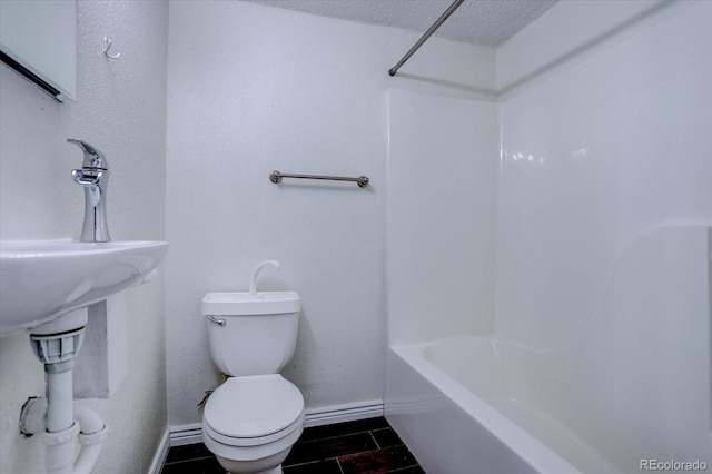 bathroom with toilet, a textured ceiling, and bathtub / shower combination