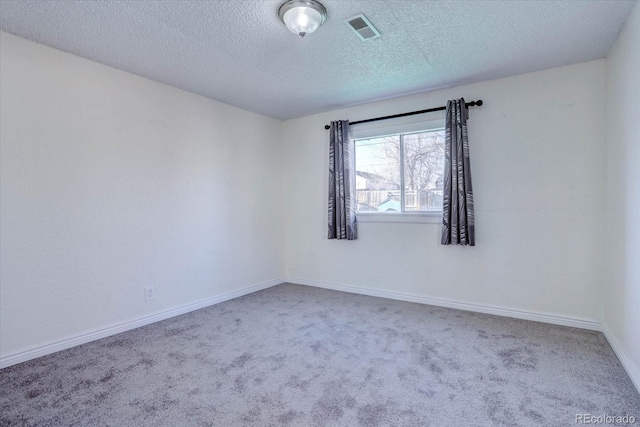 spare room with a textured ceiling and carpet