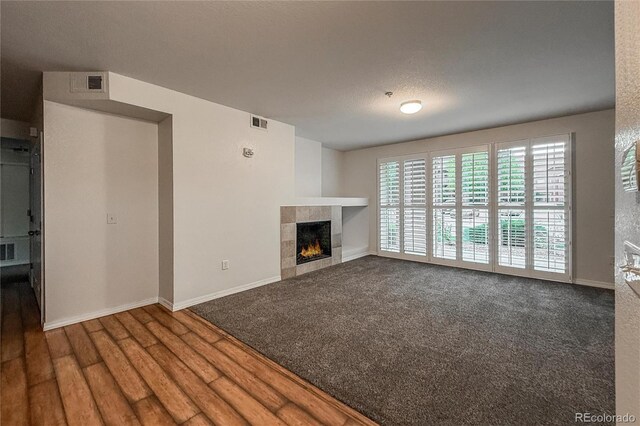 804 Summer Hawk Dr Unit 5105, Longmont, CO 80504 - unfurnished living room featuring a tile fireplace, baseboards, and carpet floors