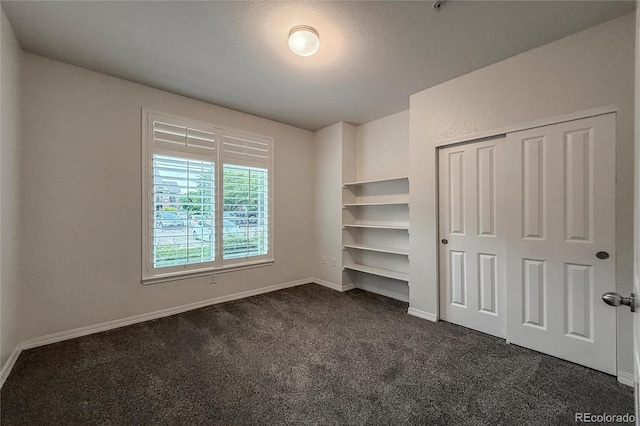 804 Summer Hawk Dr Unit 5105, Longmont, CO 80504 - unfurnished bedroom featuring dark colored carpet, baseboards, and a closet