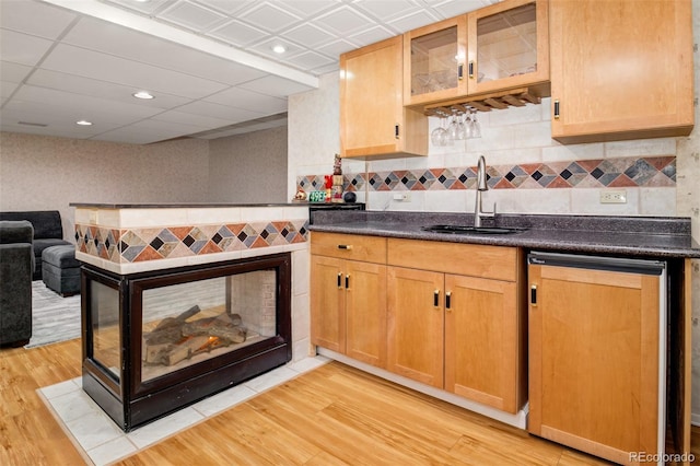 16084 Stonebriar Dr, Parker, CO 80134 - kitchen with a sink, dark countertops, light wood-type flooring, backsplash, and glass insert cabinets
