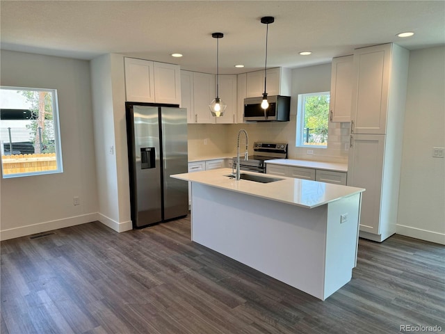 kitchen with sink, white cabinetry, hanging light fixtures, and appliances with stainless steel finishes