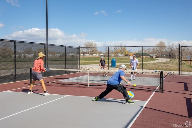 view of tennis court featuring community basketball court and fence