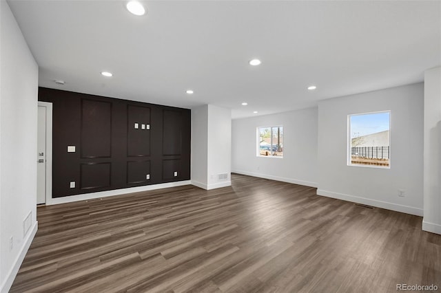 interior space with baseboards, recessed lighting, and dark wood-style floors