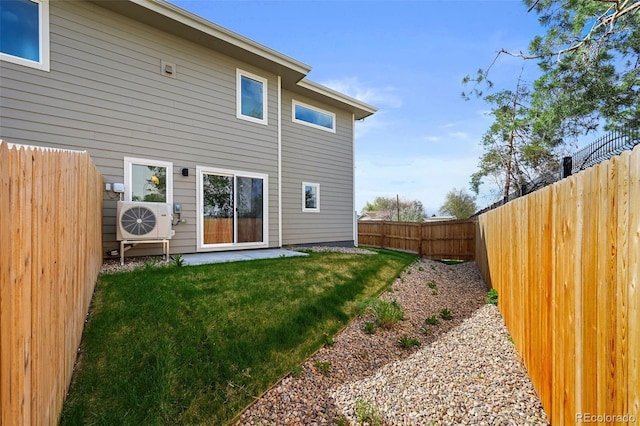 rear view of house with a lawn, a fenced backyard, and ac unit