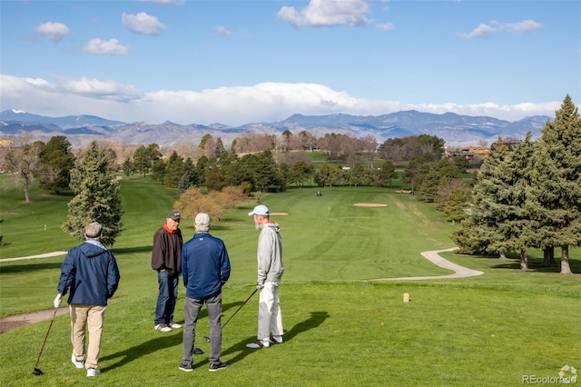 view of home's community with a mountain view, golf course view, and a lawn