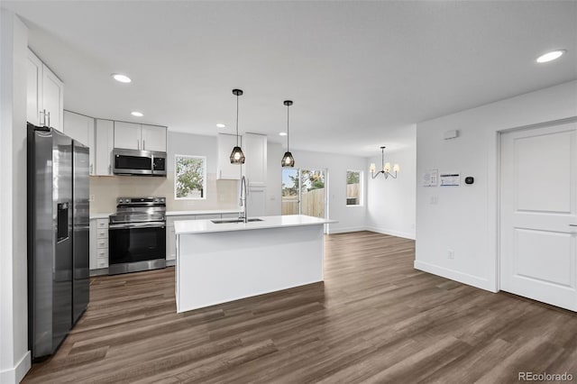 kitchen featuring a sink, stainless steel appliances, a notable chandelier, dark wood-style flooring, and light countertops