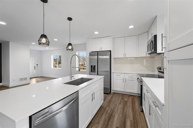 kitchen with visible vents, a sink, dark wood-type flooring, light countertops, and appliances with stainless steel finishes
