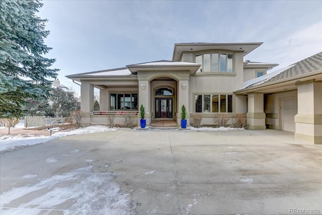 prairie-style house featuring driveway, a garage, and stucco siding