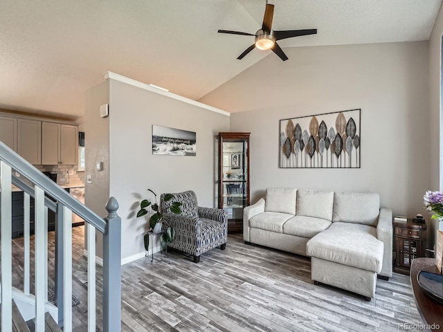 13358 Briarwood Dr, Broomfield, CO 80020 - living area with ceiling fan, light wood finished floors, stairs, high vaulted ceiling, and baseboards