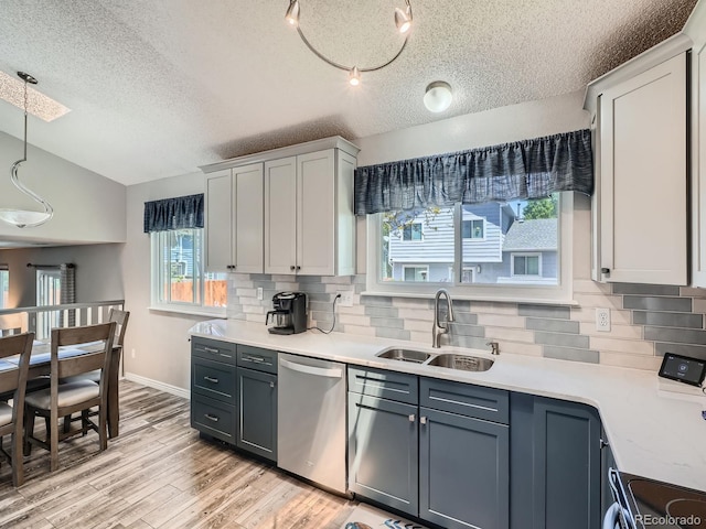 13358 Briarwood Dr, Broomfield, CO 80020 - kitchen with stainless steel dishwasher, a sink, decorative backsplash, light countertops, and a textured ceiling