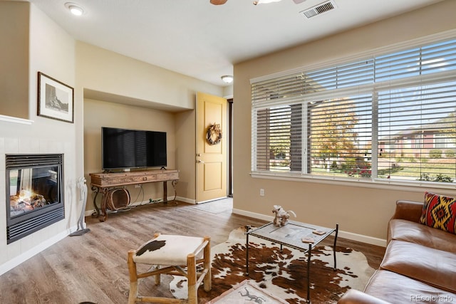 living room with a healthy amount of sunlight, a fireplace, and light wood-type flooring