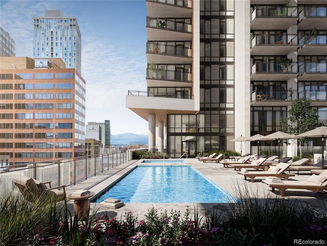 pool featuring a patio, fence, a mountain view, and a city view