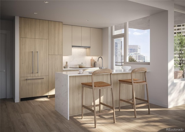 kitchen with a peninsula, light countertops, a view of city, modern cabinets, and a kitchen bar