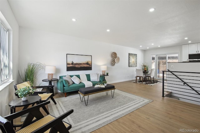 living area featuring baseboards, wood finished floors, and recessed lighting