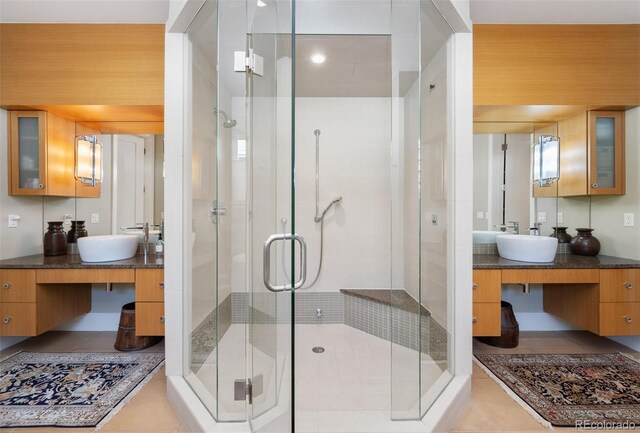 full bathroom with a stall shower, vanity, and tile patterned floors