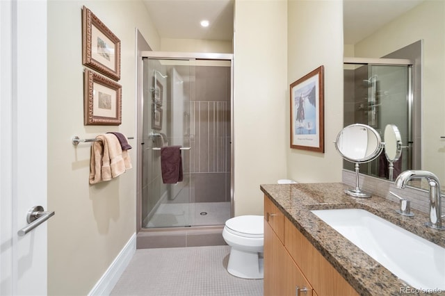 full bath with a stall shower, vanity, tile patterned floors, and toilet