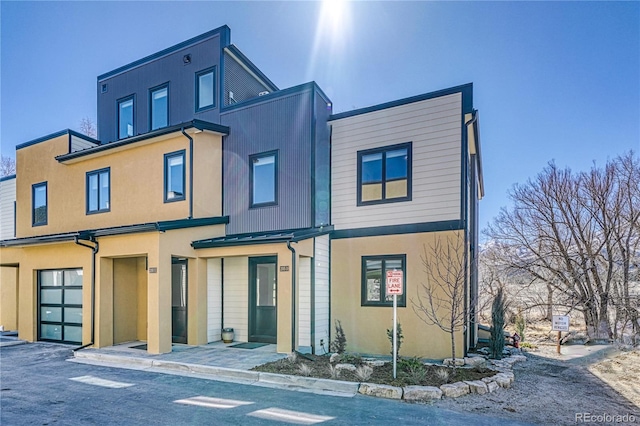 townhome / multi-family property with stucco siding and an attached garage