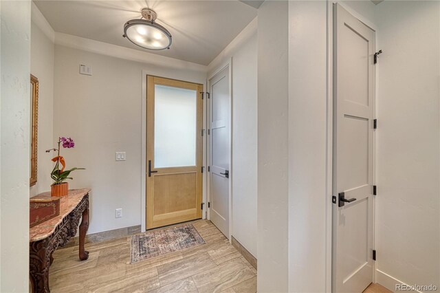 foyer with baseboards and light wood-style flooring