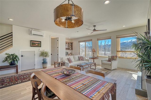 living area featuring recessed lighting, a wall mounted air conditioner, and light wood finished floors