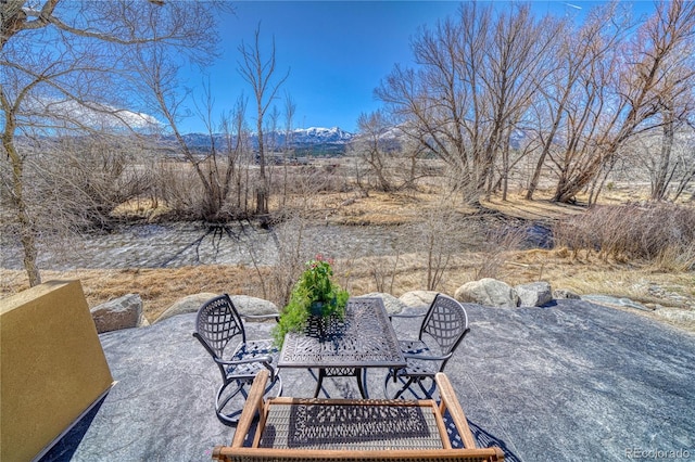 view of patio with a mountain view and outdoor dining space