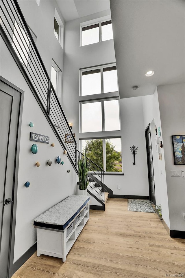 21345 E 59th Dr, Aurora, CO 80019 - entryway with stairs, a high ceiling, light wood-style flooring, and recessed lighting