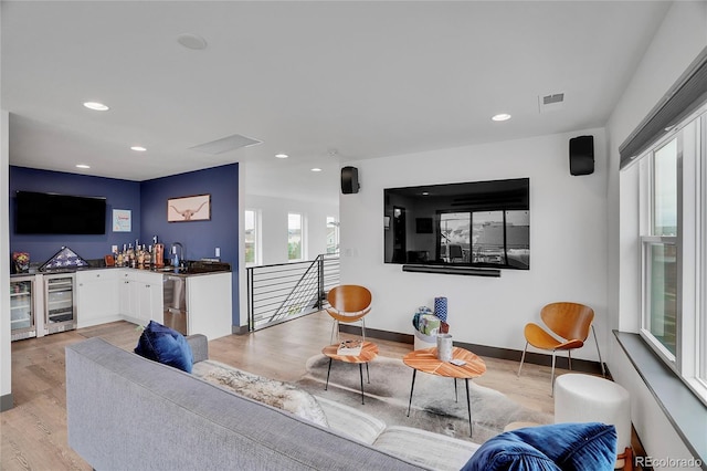 21345 E 59th Dr, Aurora, CO 80019 - living room featuring beverage cooler, bar with sink, light wood finished floors, and recessed lighting
