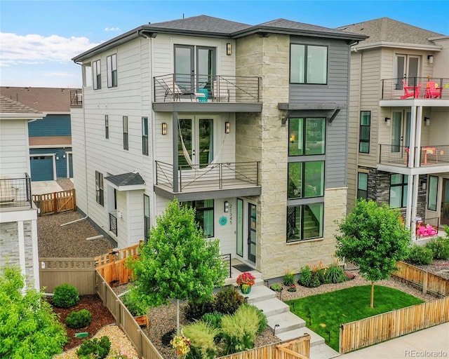 21345 E 59th Dr, Aurora, CO 80019 - view of front of property featuring a balcony, a fenced backyard, and stone siding