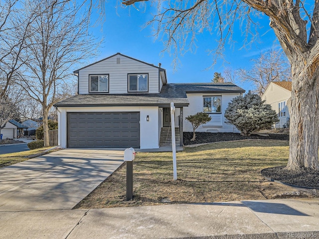 tri-level home with driveway, roof with shingles, a garage, and a front yard