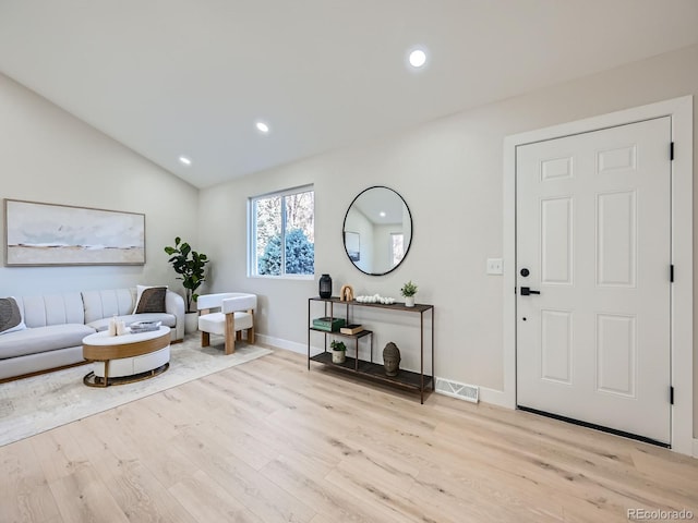 living area with baseboards, visible vents, lofted ceiling, light wood-style floors, and recessed lighting