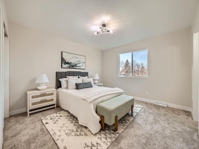 carpeted bedroom featuring baseboards and visible vents