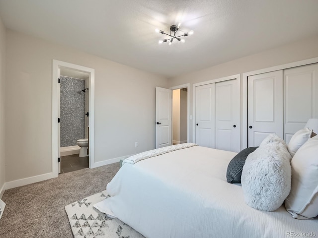 bedroom with baseboards, ensuite bath, an inviting chandelier, carpet, and two closets