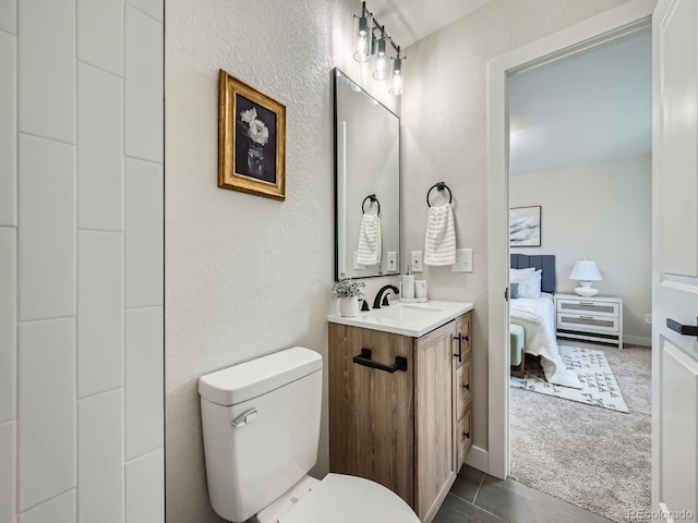 bathroom featuring a textured wall, vanity, toilet, and ensuite bathroom