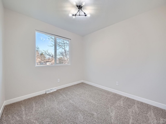 carpeted empty room with visible vents and baseboards