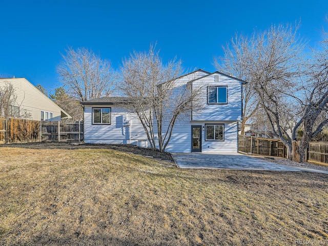 rear view of property with a patio, a lawn, and a fenced backyard