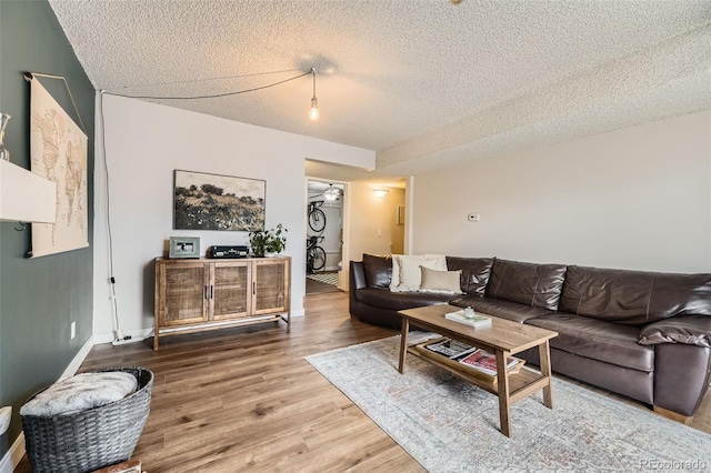 3141 S Tamarac Dr Unit 202E, Denver, CO 80231 - living area with baseboards, a textured ceiling, and wood finished floors