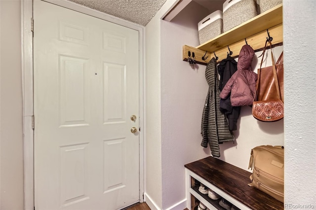 3141 S Tamarac Dr Unit 202E, Denver, CO 80231 - mudroom featuring baseboards and a textured ceiling